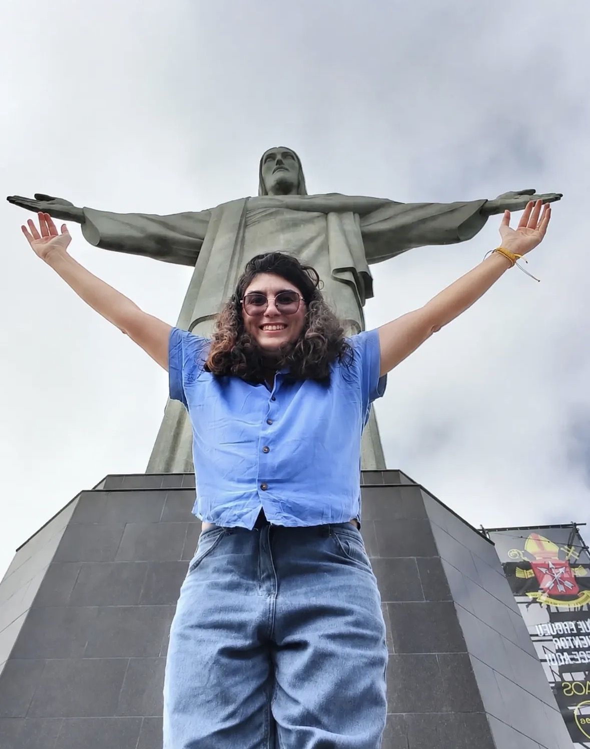 Visitor with daypack and hat standing on the Corcovado viewing platform in sunshine